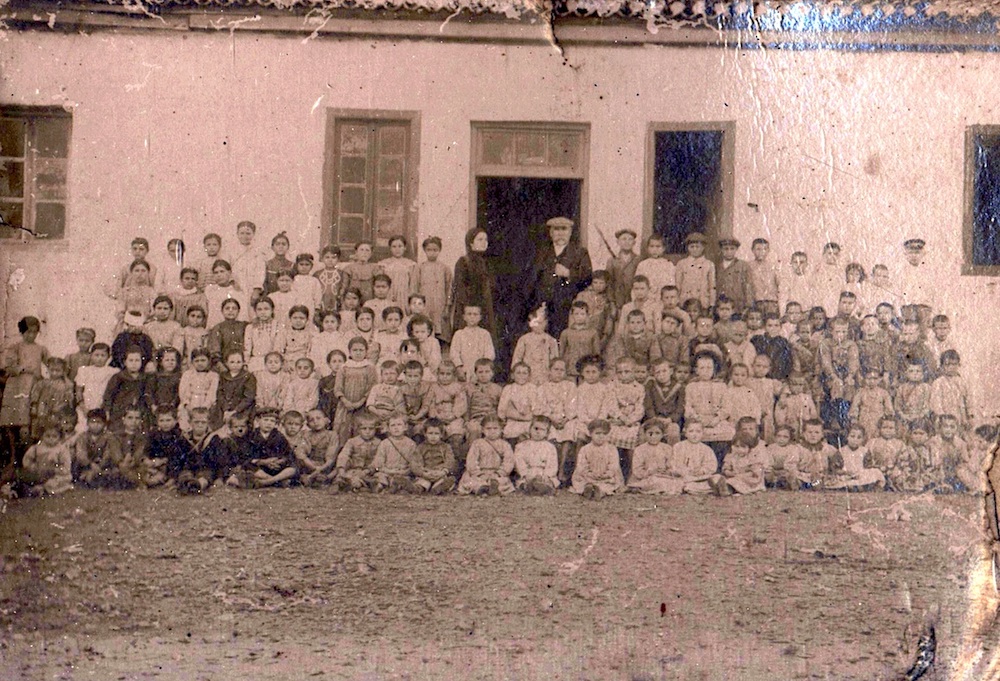 Η φωτογραφία απεικονίζει τον δάσκαλο του σχολείου του μεγα λιβαδιου σεριφου με τους μαθητές στις αρχές του 20ου αιώνα.